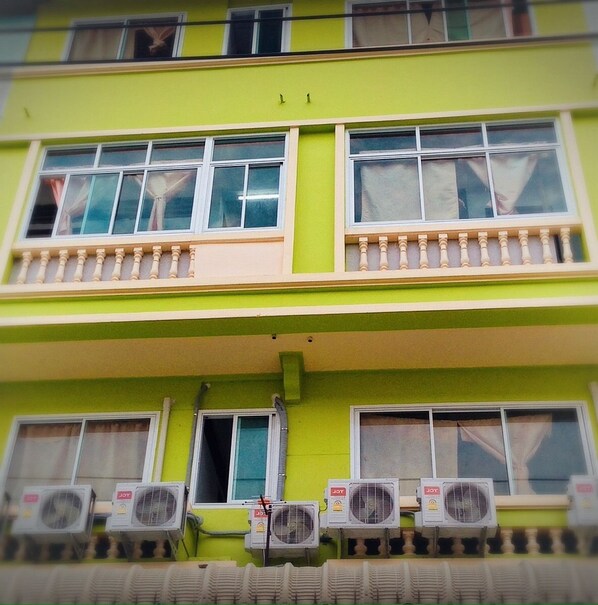 A multi-story building with balconies and air conditioning units.