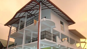 Un immeuble à plusieurs étages doté de balcons, d’un escalier et d’un drapeau.