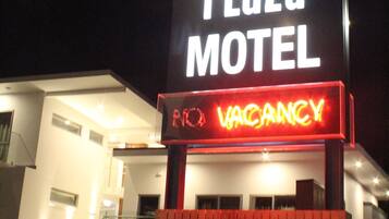A motel sign with "97 Bealey Plaza" and "VACANCY" displayed.