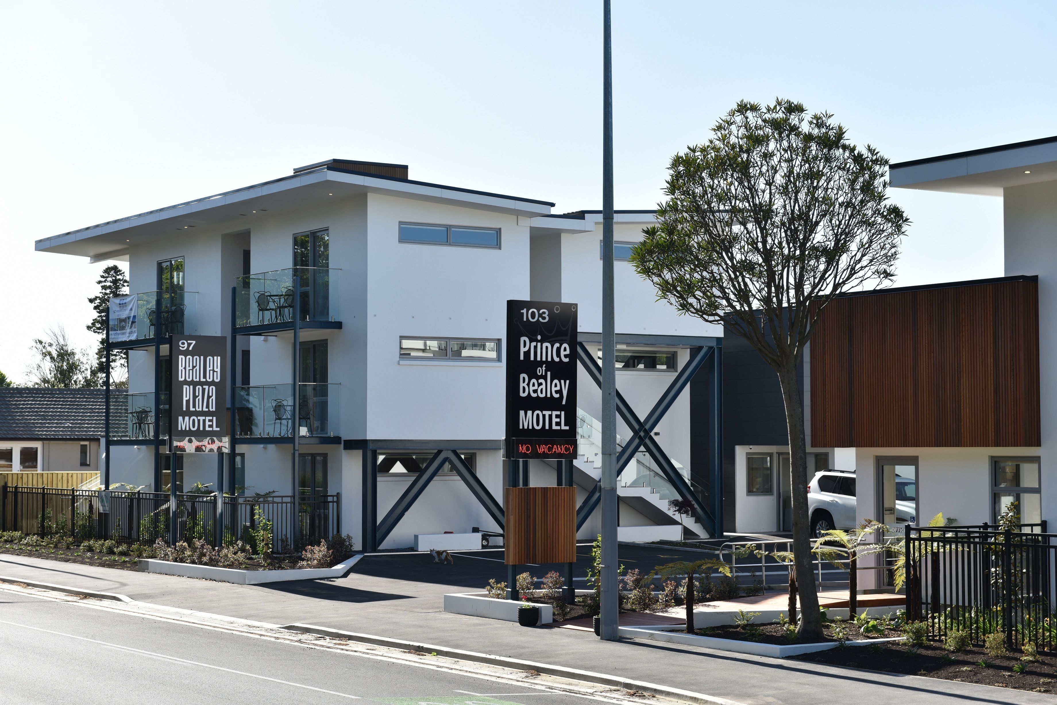 Et moderne motel med et skilt, der viser '103 Prince of Bealey Motel' og 'Udsolgt'.