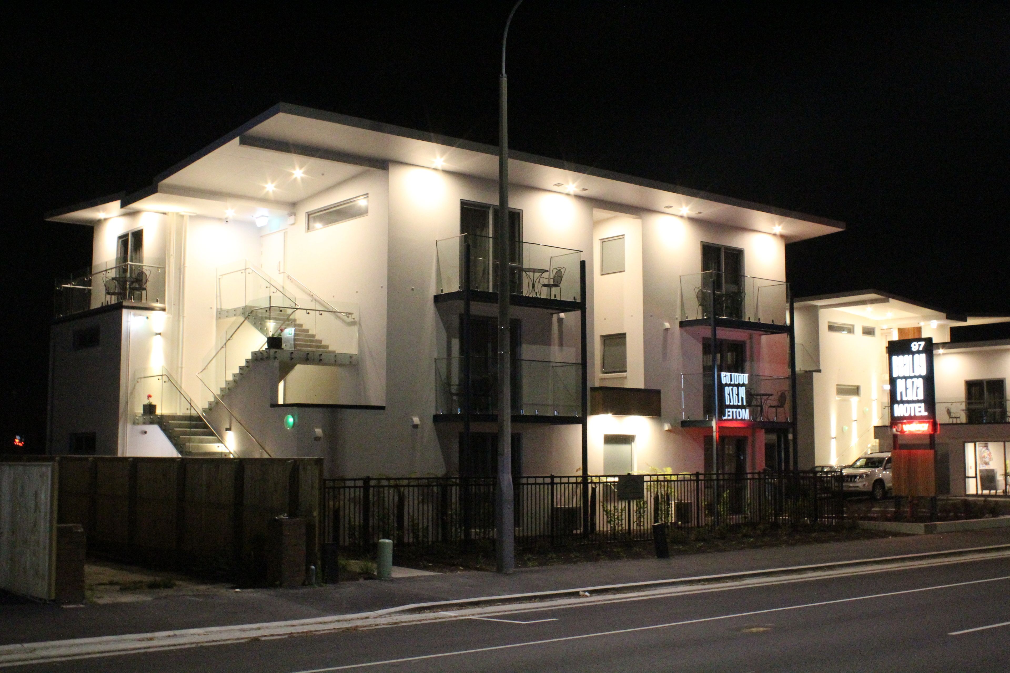 A modern building with a staircase, a balcony, and a sign for a motel.