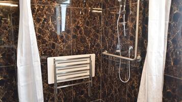 A modern shower area with a curved showerhead, a handheld shower, and a handheld showerhead.
