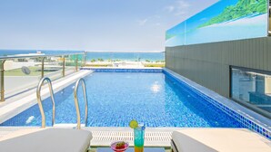 A pool with a clear view of the ocean, a bar area with drinks, and a modern architectural design. - Haka Hotel & Apartment (Da Nang)