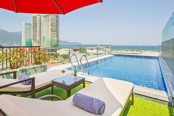 Una piscina al aire libre, sillones reclinables de piscina