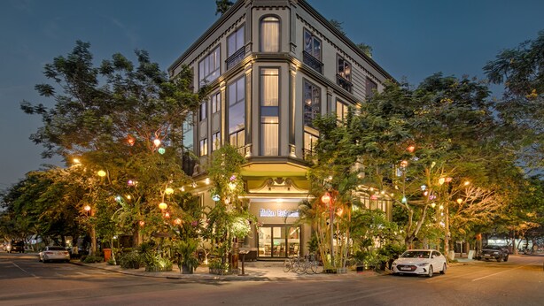 A corner building with a restaurant named "Hoko Restaurant" at the entrance, surrounded by trees and street lamps. - Haka Hotel & Apartment (Da Nang)