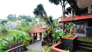 Un patio con un pabellón, plantas en macetas y un sendero de piedra.