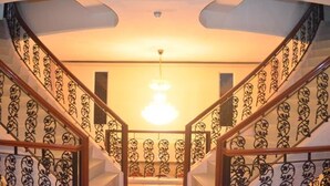 A staircase with ornate metal railings and a central light fixture.