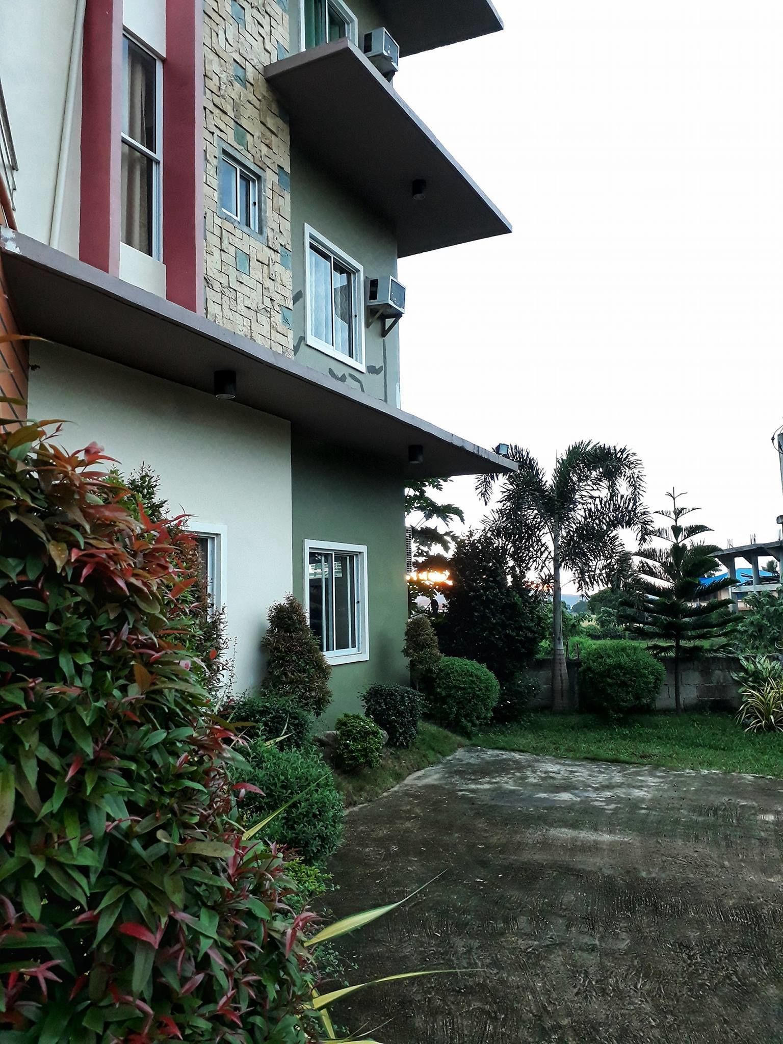A two-story building with a flat roof and a small front garden.