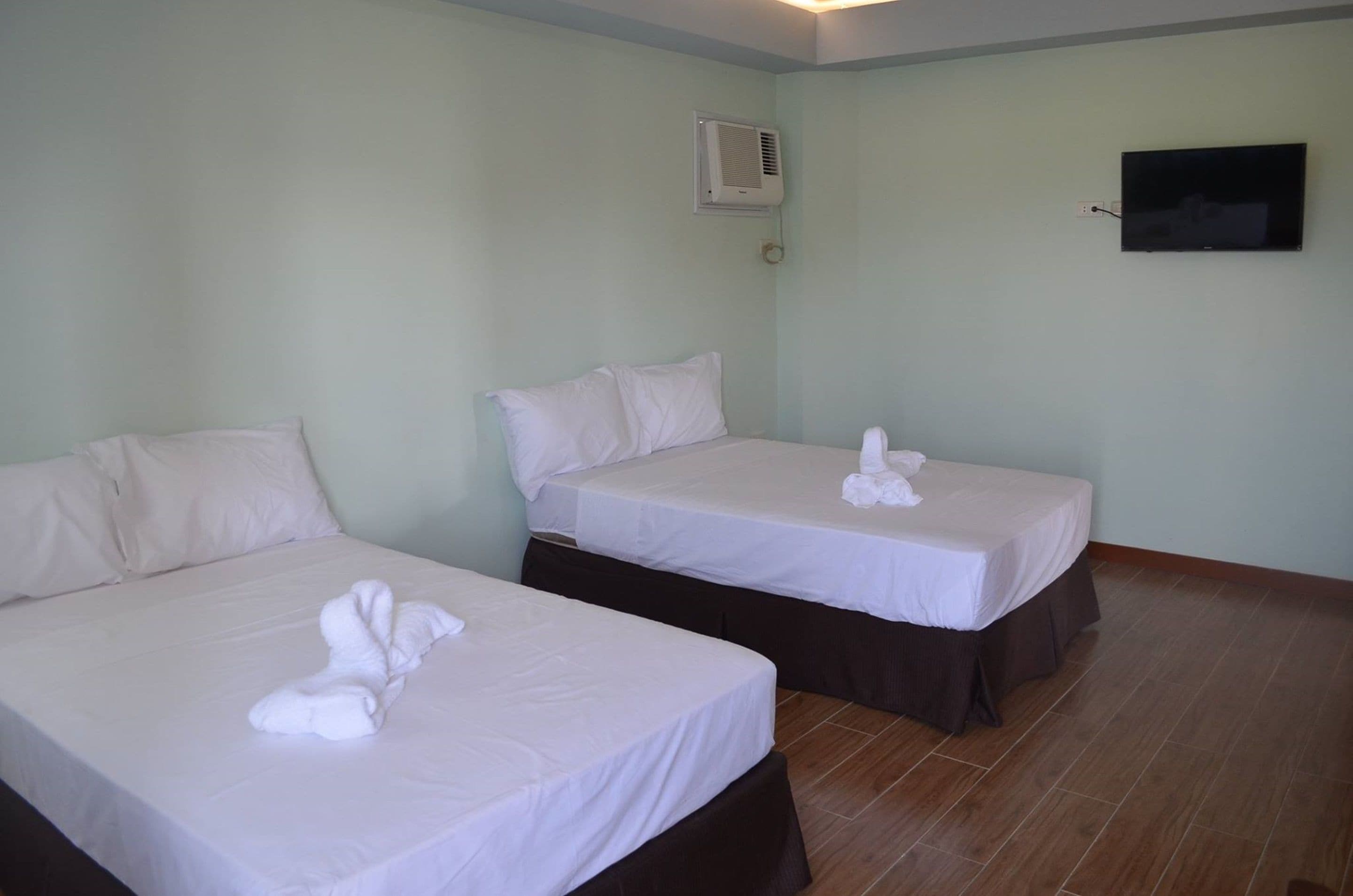 Habitación de hotel con dos camas, cada una con ropa blanca y toallas.