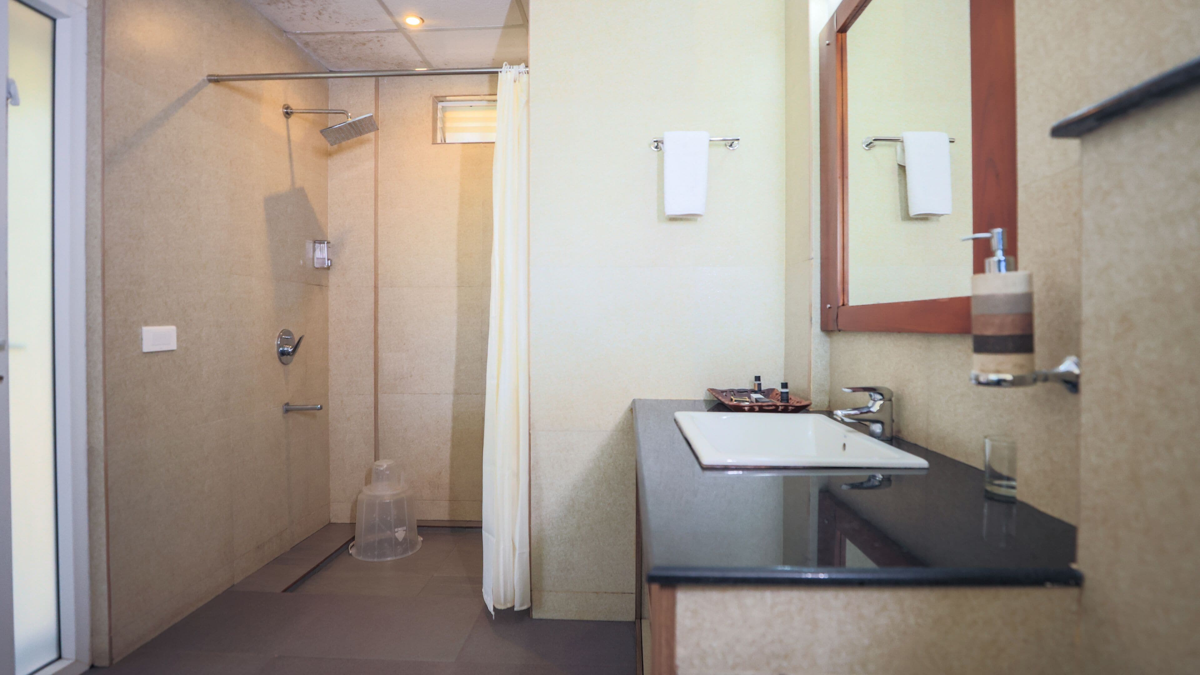 A bathroom with a shower, a sink, and a mirror.