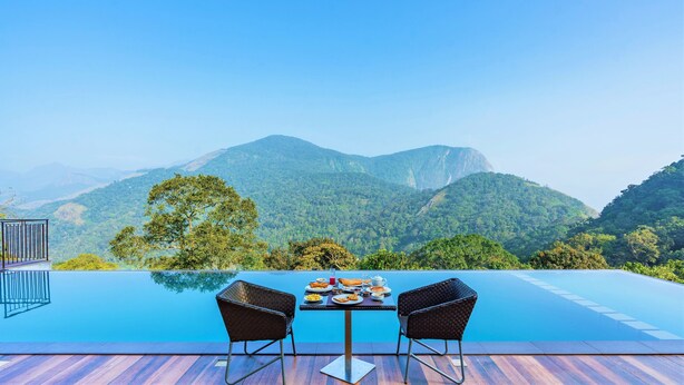 Un espace repas avec une table et des chaises donnant sur un paysage montagneux.