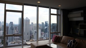 Een moderne woonkamer met grote ramen en uitzicht op de stad.