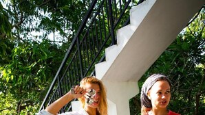 Two people walking on a staircase with a tray of drinks. - Horizon Inn (Weligama)