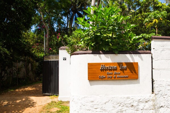 Letrero de una casa de huéspedes con la inscripción 'Horizon Inn' y 'Casa de Huéspedes', junto con el rótulo 'Cafetería y Restaurante'.