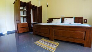 A bedroom with a wooden bed, a wardrobe, and a small rug. - Horizon Inn (Weligama)