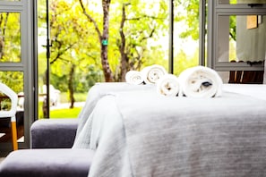 A room with a bed, a chair, and a view of trees through a window. - Bushbaby Lodge at Nkonyeni (Sidvokodvo)
