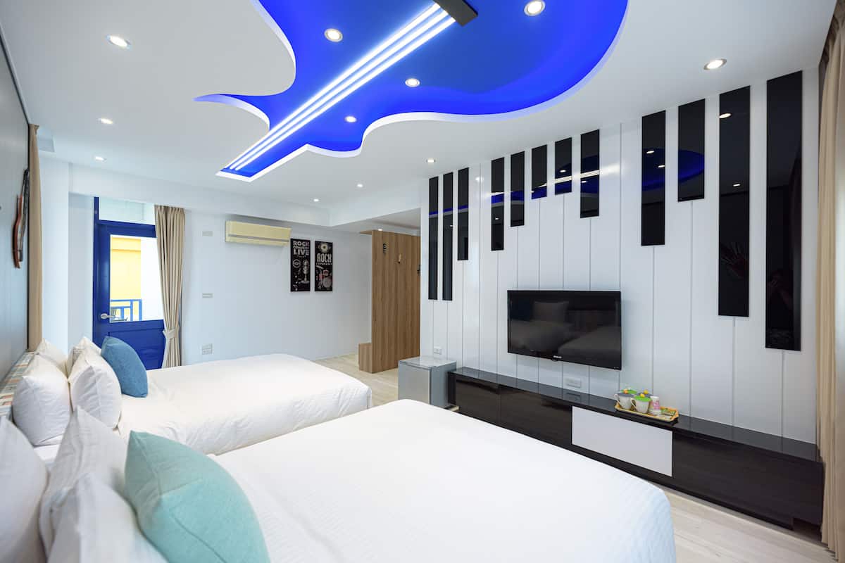 A modern hotel room with two beds, a TV, and a unique ceiling design.