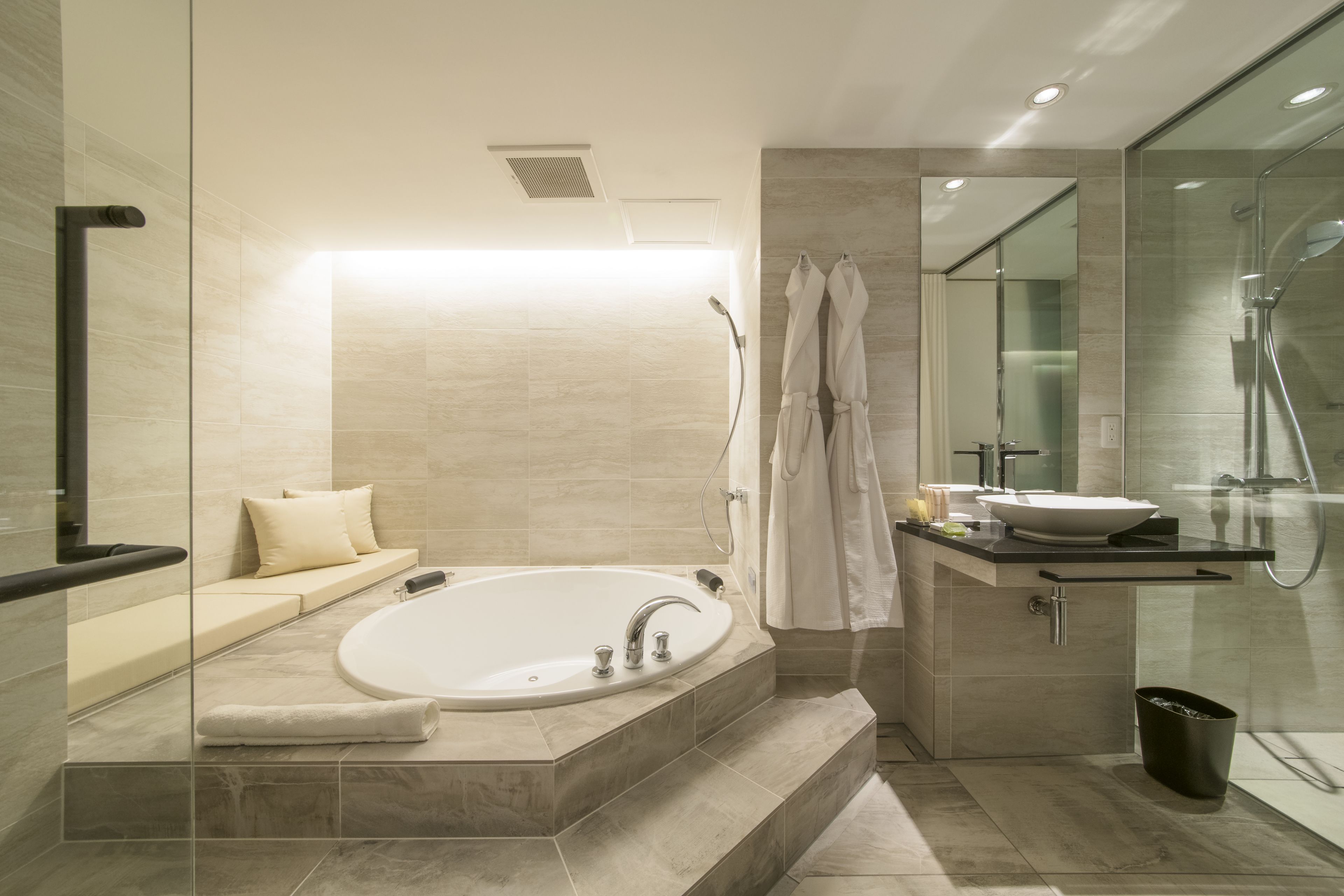 A modern bathroom with a freestanding bathtub, a glass-enclosed shower, and a vanity with a sink.