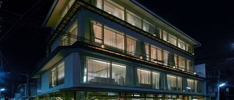 Un edificio de varios pisos con grandes ventanales y balcones, que presenta un diseño arquitectónico moderno.