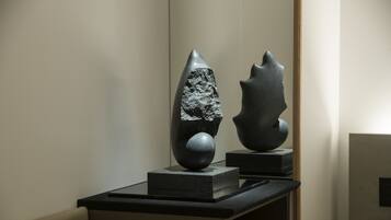 A sculpture on a pedestal in a gallery setting.
