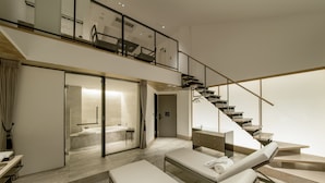 A modern hotel room with a spacious living area, a large window, and a staircase leading to an upper floor. - Art Mon Zen Kyoto (Kyoto)