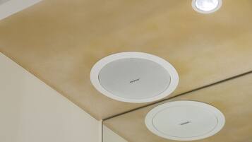 A ceiling with two circular vents and a textured panel.