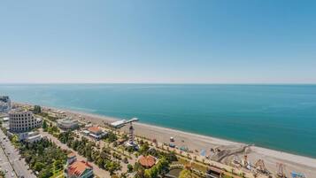 Eine Küstenstadt mit Strand, Gebäuden und einem Turm.