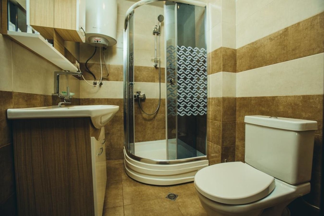 A modern bathroom with a glass-enclosed shower, a sink, and a toilet.