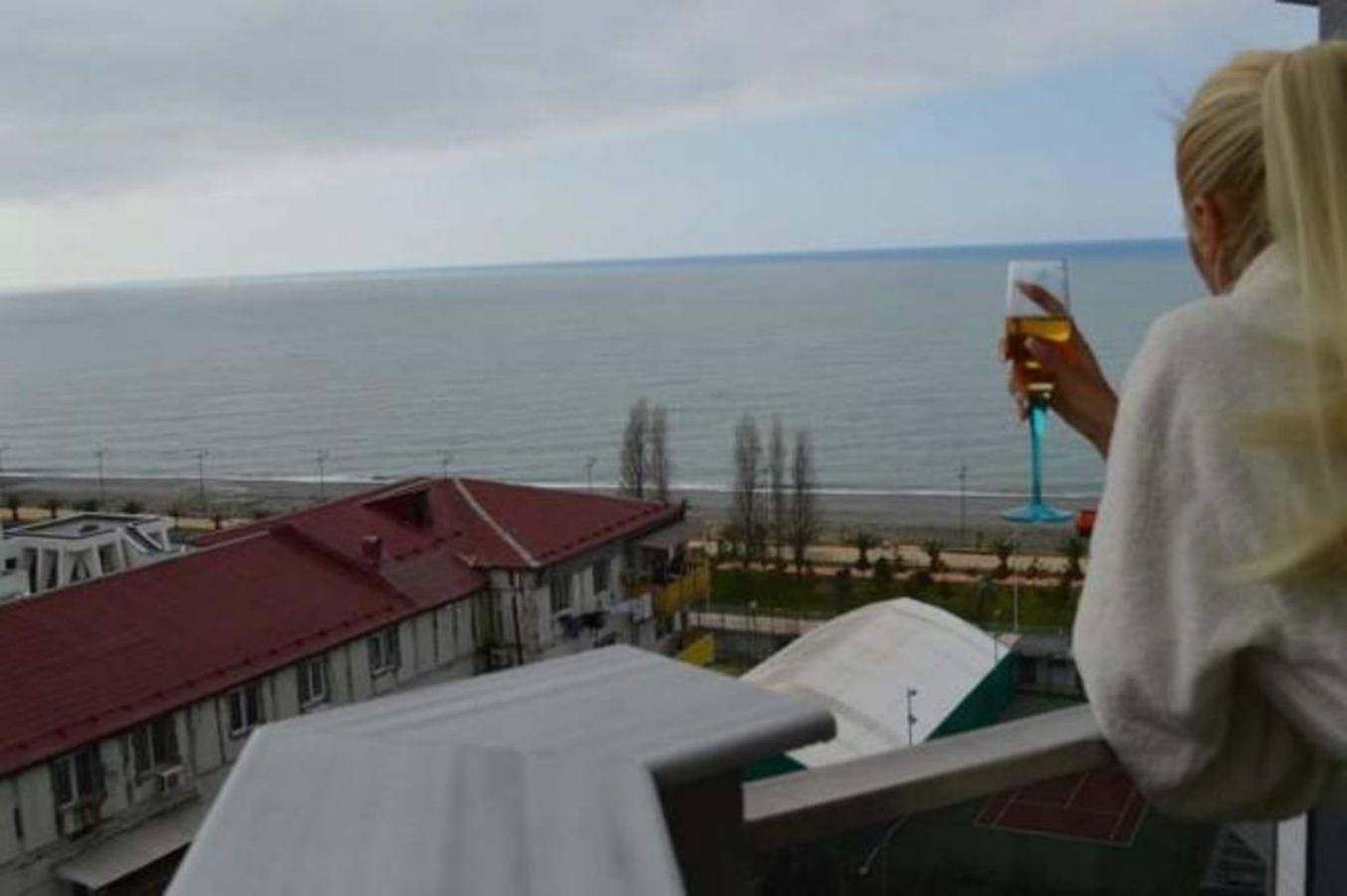 A balcony overlooking a body of water with buildings in the background.