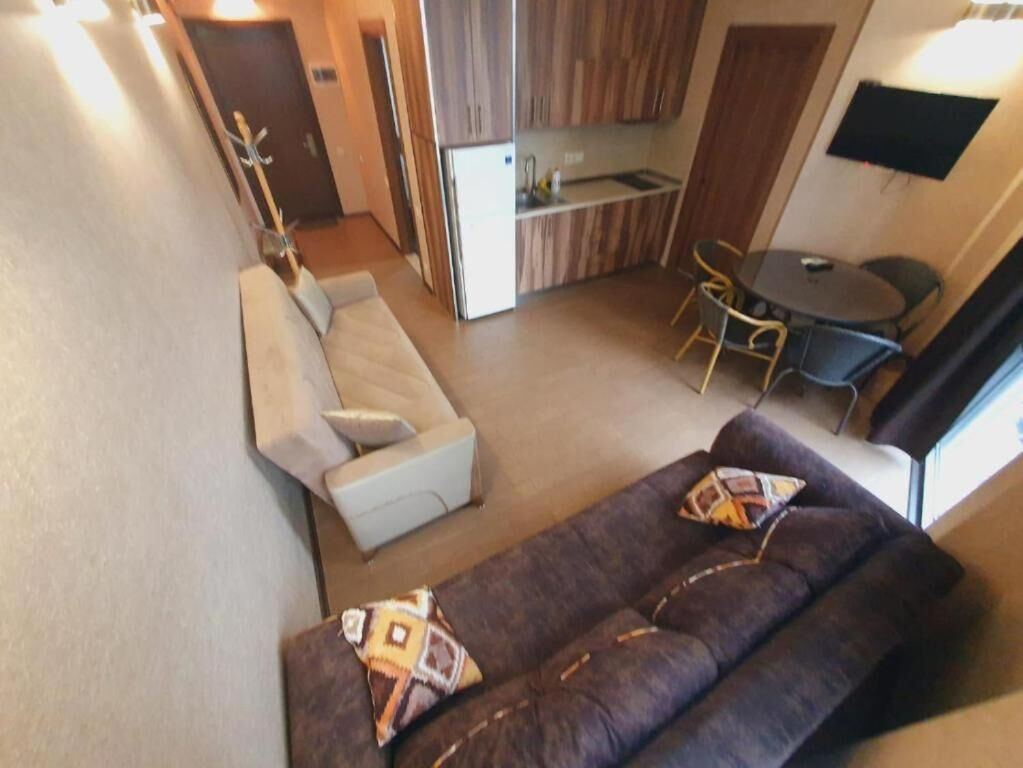 Un espace de vie compact comprenant un canapé, une table à manger et une kitchenette.