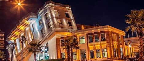A modern hotel with a unique angular design, featuring multiple levels and a prominent entrance with steps.