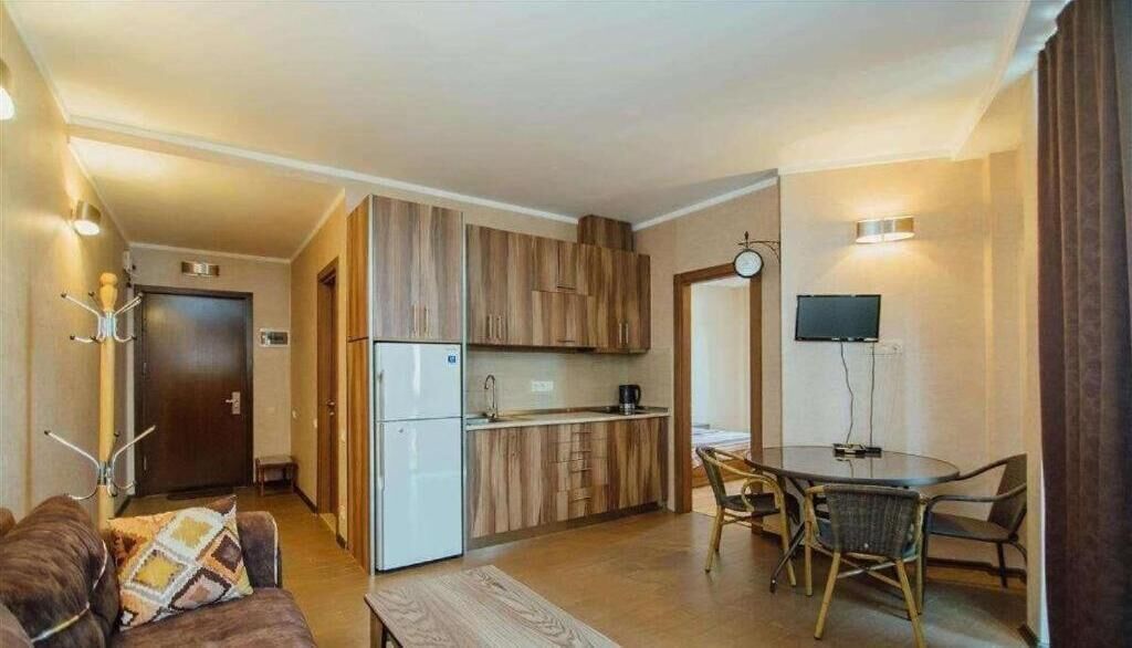 A compact living space with a kitchenette, a dining area, and a seating area.
