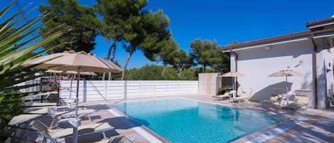 Piscine extérieure en saison, piscine à débordement, chaises longues