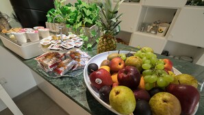 A kitchen counter with a variety of fruits and packaged snacks.
