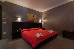 A modern bedroom with a large bed, a painting on the wall, and two bedside tables. - Bed and breakfast Nacorè (Massafra)