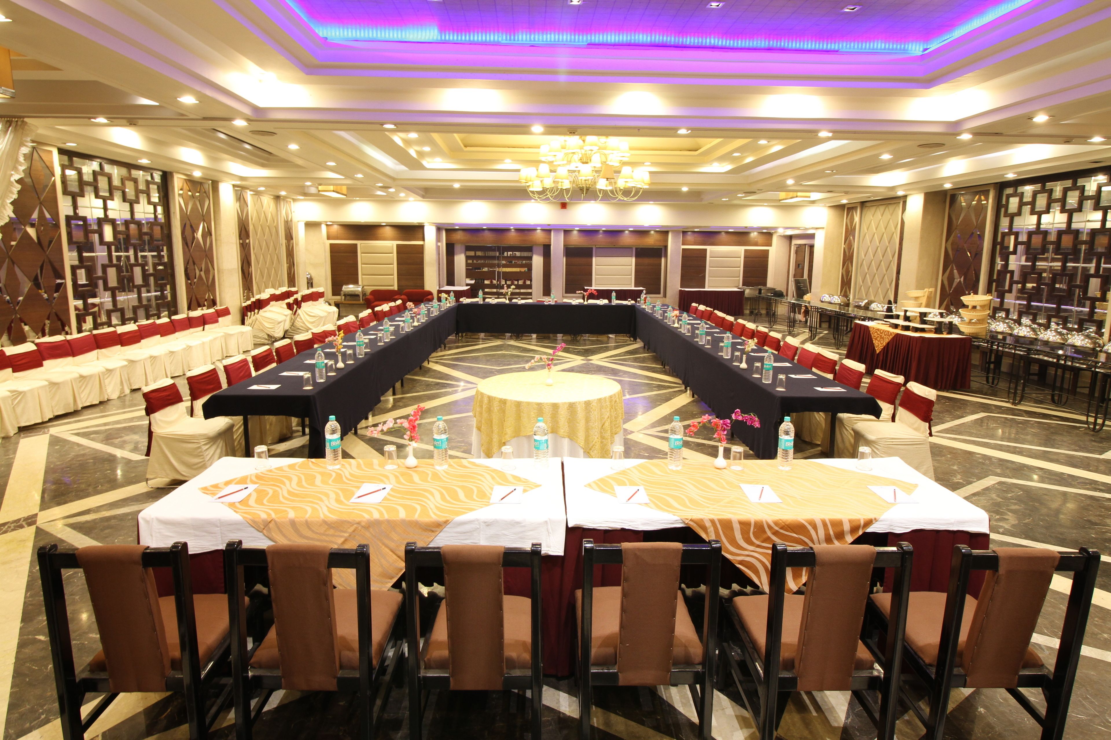 A conference room with a long table, multiple chairs, and a chandelier.
