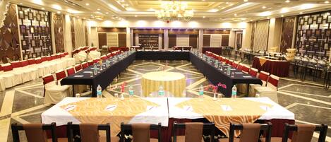 A conference room with a long table, multiple chairs, and a chandelier.