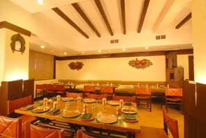 Enjoy a casual dining experience with friends and family at this communal table, set with plates, cutlery, and napkins.