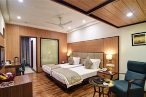 Relax in this stylish room with a large bed, desk, and ceiling fan.