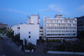 Hotel Chanaky features a modern architectural design with a prominent sign and large windows.