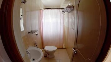 Un baño con inodoro, bidé y lavamanos.
