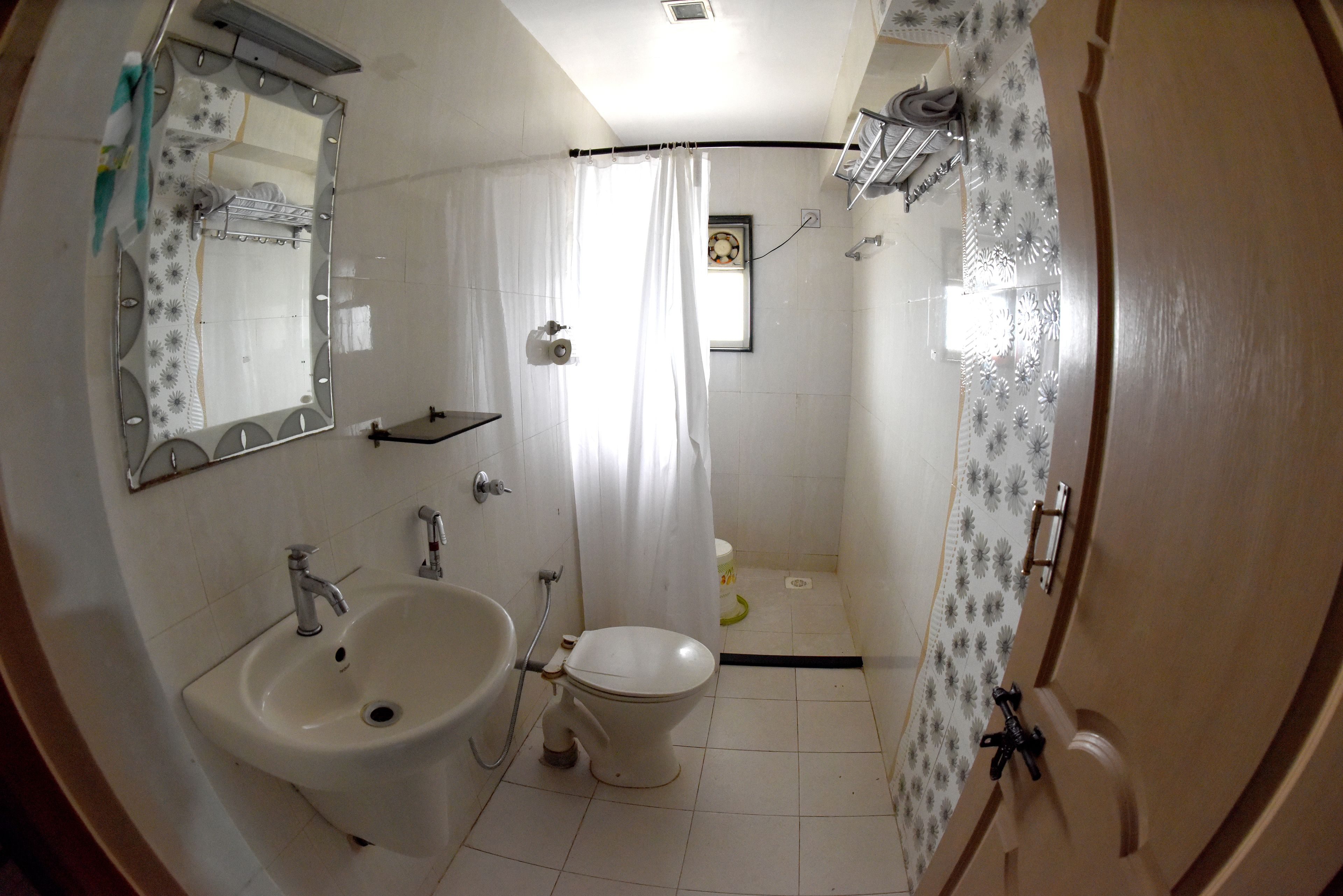 Un baño con lavamanos, inodoro y zona de ducha.