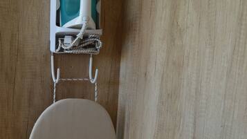A corner of a room with a wooden floor and a white chair.