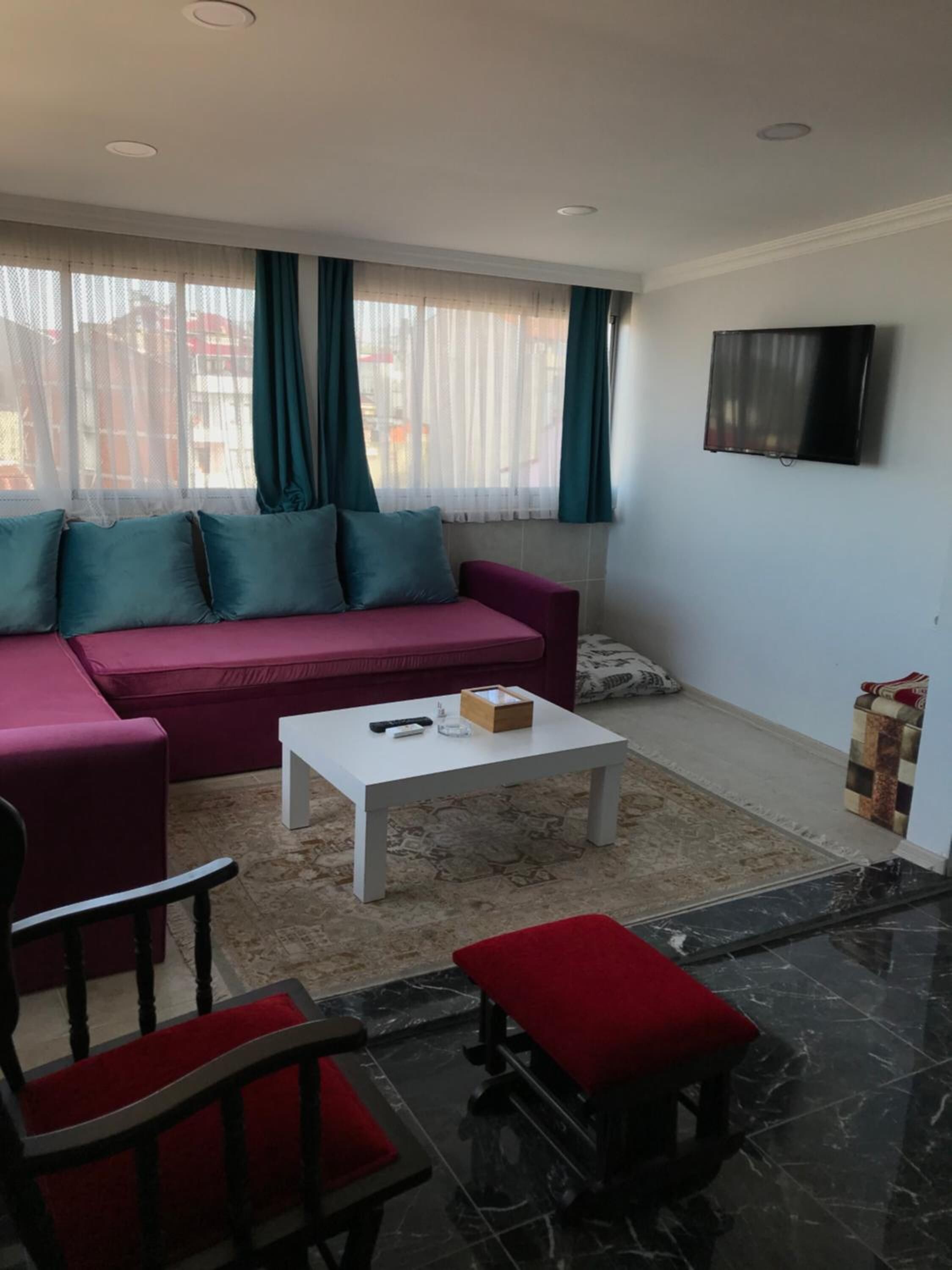 A living room with a sofa, a coffee table, a TV, and a chair.