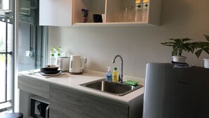 A modern kitchen with a built-in sink, a kettle, and a refrigerator. - dcondo mine by BP (Kathu)