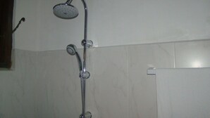 Ducha con cabezal de ducha de mano y mandos en la pared.