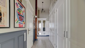 A hallway with white doors, a chandelier, and framed posters on the wall. - Scandi Love BestSeller by Lion Apartments Sopot (Sopot)