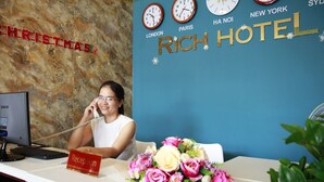 Mostrador de recepción de hotel con relojes que marcan la hora en Londres, París, Hong Kong y Nueva York.