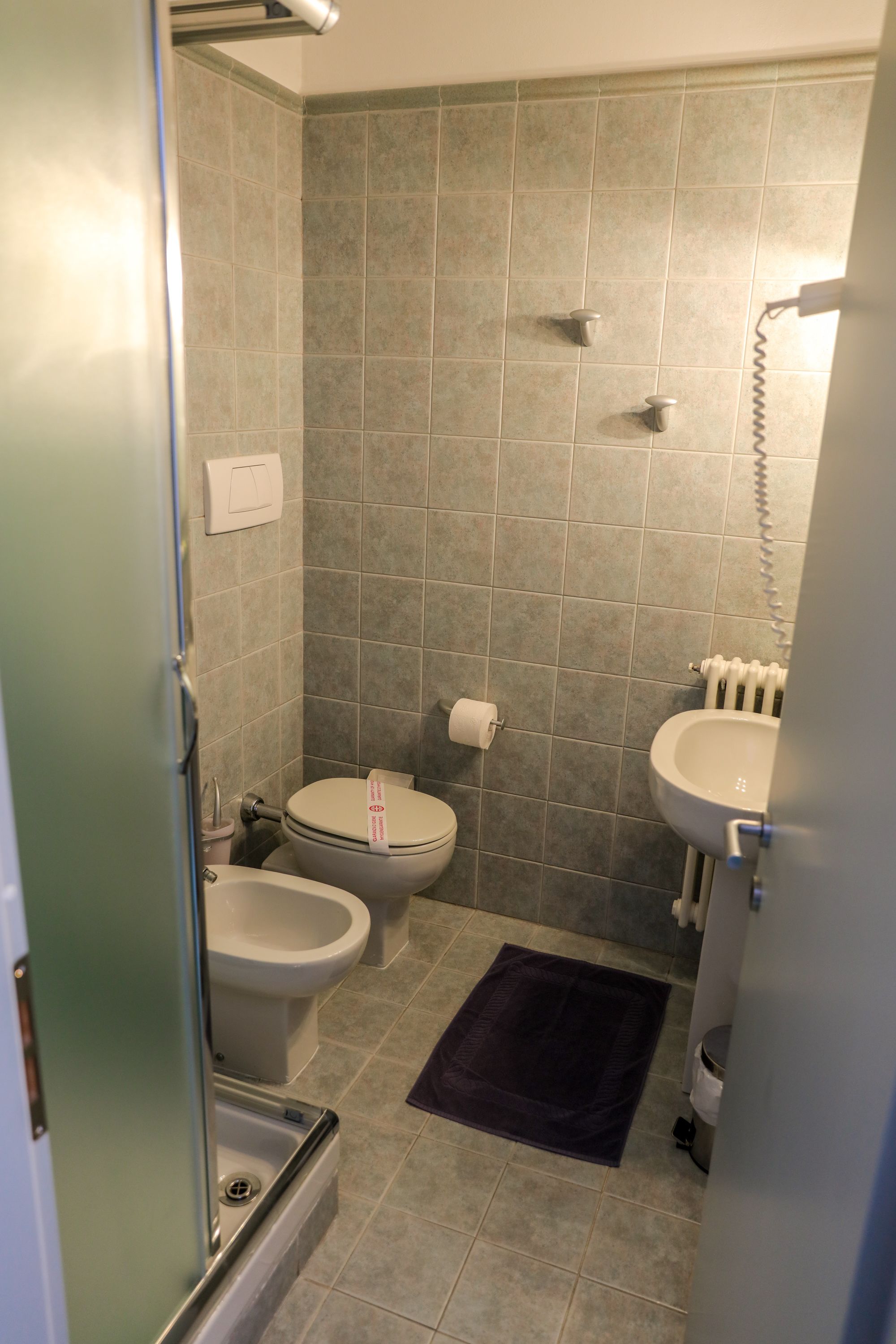 Un baño pequeño con inodoro, bidé y lavamanos.