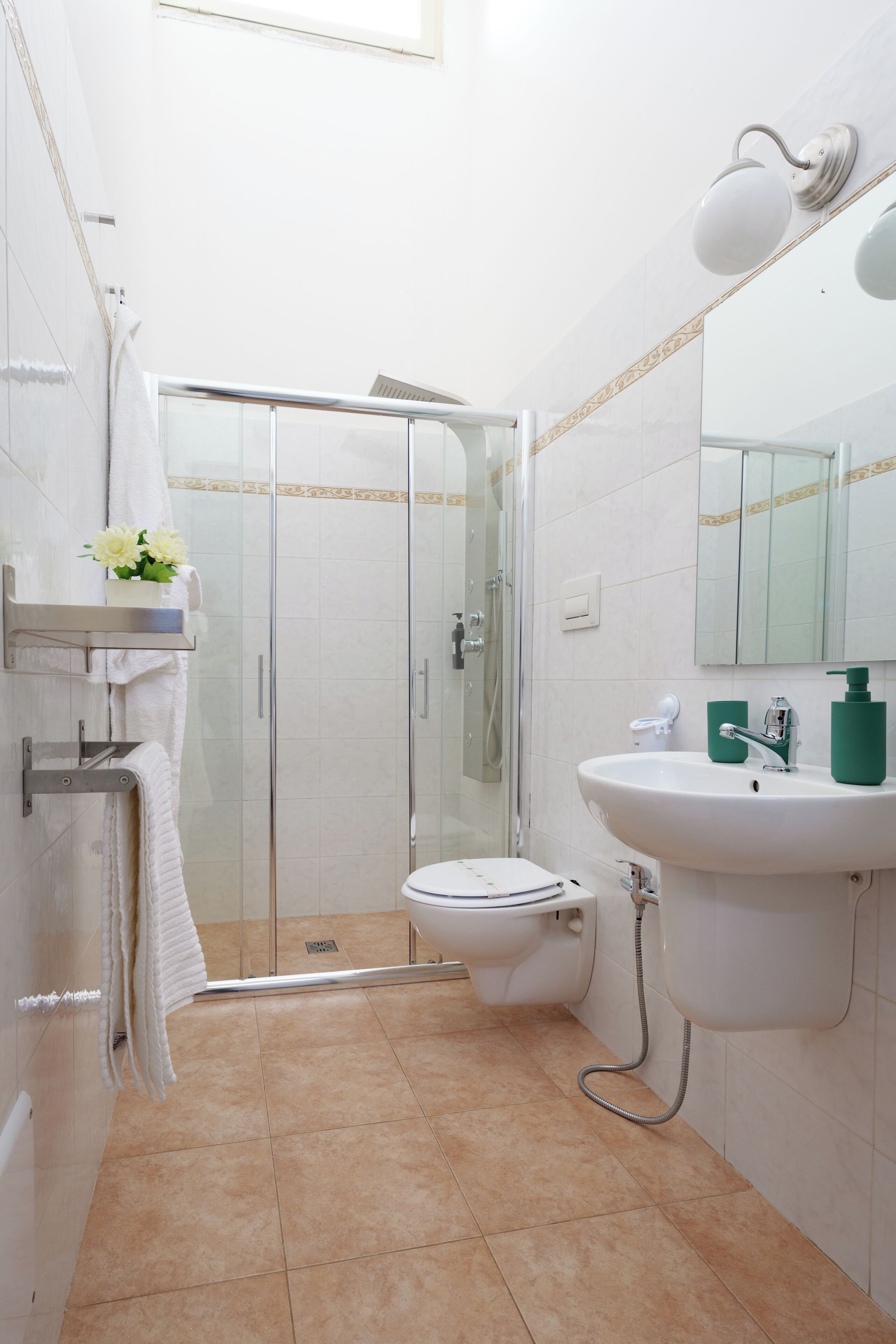 Une salle de bain moderne avec une douche à parois de verre, un lavabo blanc et des toilettes.